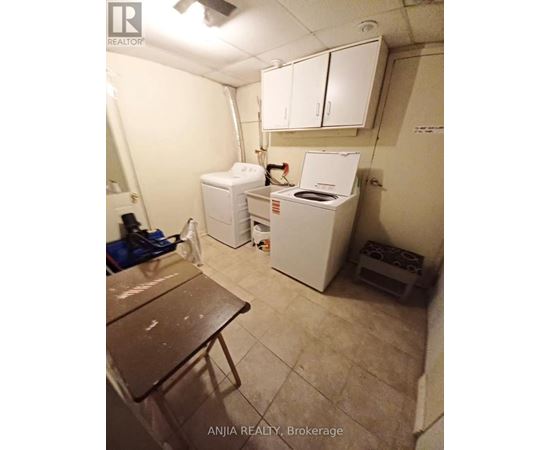 A small room with a washing machine and a table.