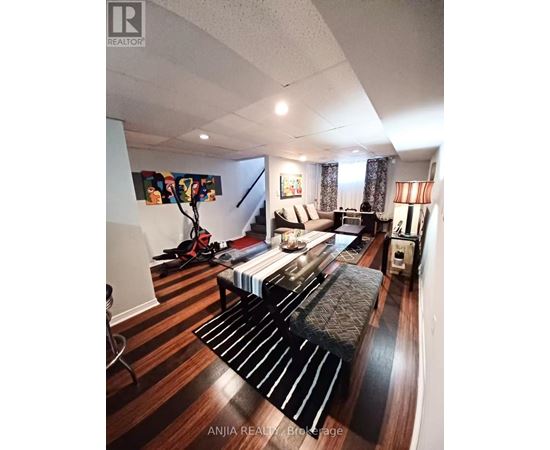 A living room with a couch and a painting on the wall.