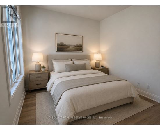 A bedroom with a large bed, two lamps, and a painting on the wall.