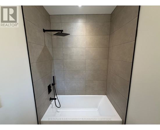 A white bathtub with a shower head and hand held shower in a bathroom.