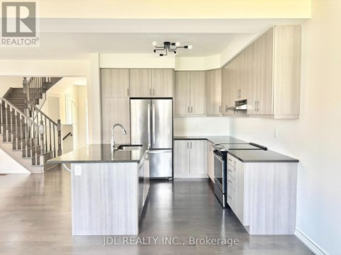 A modern kitchen with stainless steel appliances and white cabinets.