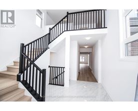 A white interior with a black railing staircase.