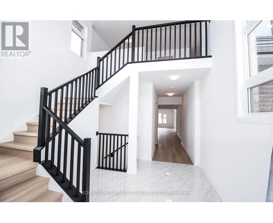 A white interior with a black railing staircase.