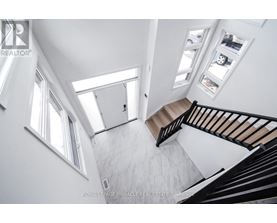 A staircase with a black railing and a white wall.
