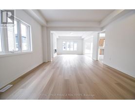 A spacious room with wooden flooring and white walls.