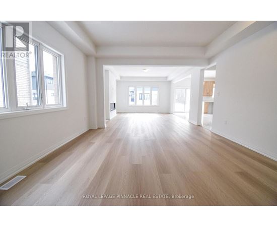 A spacious room with wooden flooring and white walls.