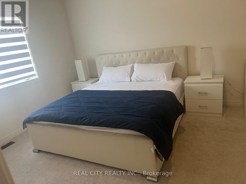 A bedroom with a bed, nightstand, and lamp.