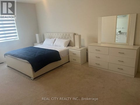 A bedroom with a bed, dresser, and mirror.