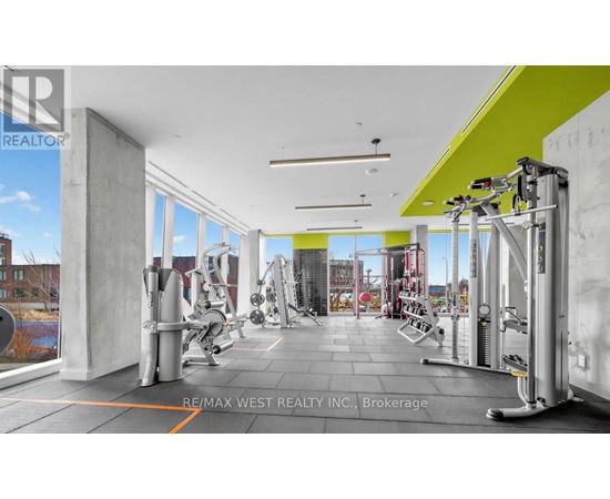 A gym with a green and white wall and a row of treadmills.