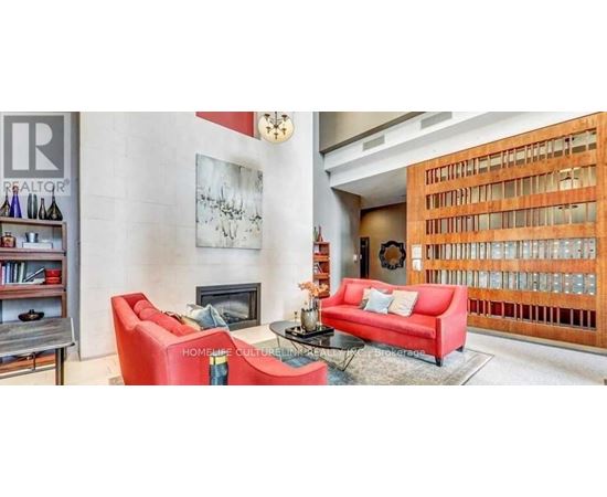 A living room with a red couch and a fireplace.