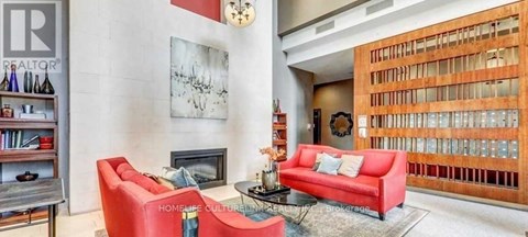 A living room with a red couch and a fireplace.