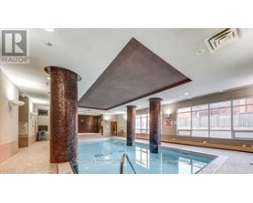 A large indoor swimming pool with a brown ceiling and columns.