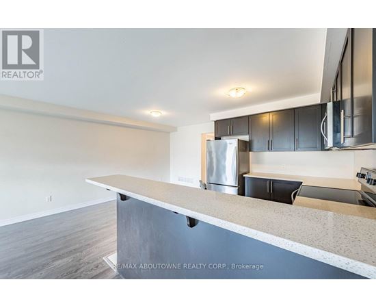 A modern kitchen with a stainless steel refrigerator and black cabinets.
