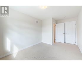 A white bedroom with a carpet floor and a white ceiling.