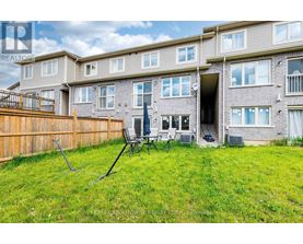 A large grassy yard in front of a multi-story apartment building.