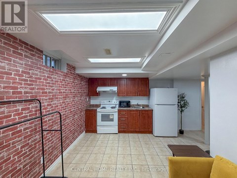 A kitchen with a white refrigerator and wooden cabinets.