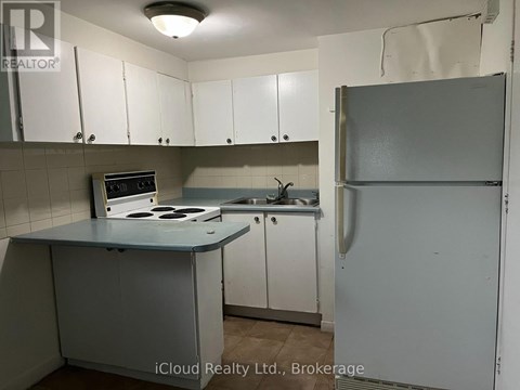 A kitchen with white cabinets and a white refrigerator.
