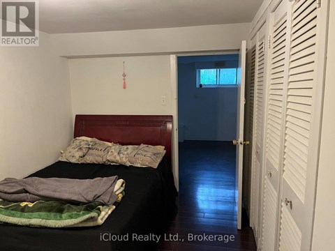 A bedroom with a bed, a window, and a door.