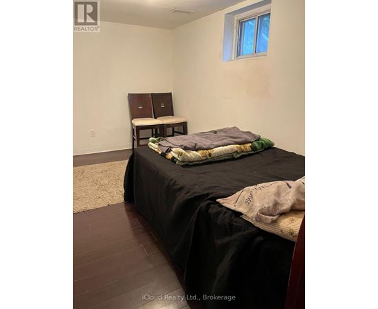 A bedroom with a bed, a desk, and a window.
