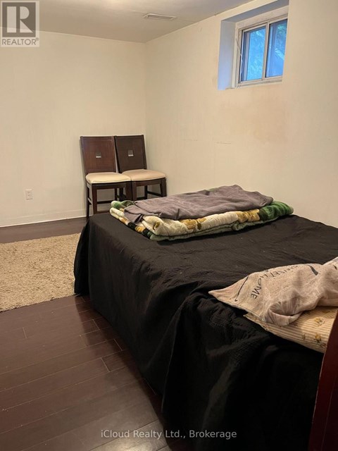 A bedroom with a bed, a desk, and a window.