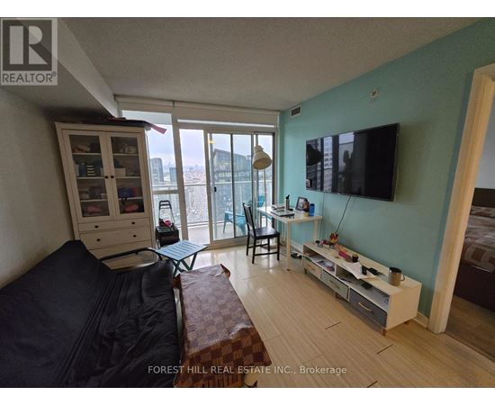 A living room with a couch, a chair, a desk, and a television.