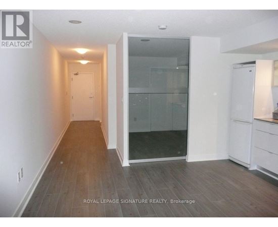 A room with a glass door and wooden flooring.