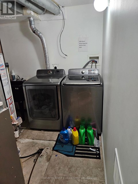 A room with a stainless steel oven and a paper towel dispenser.