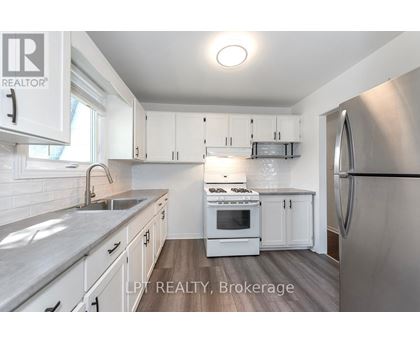 A modern kitchen with white cabinets and stainless steel appliances.