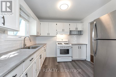 A modern kitchen with white cabinets and stainless steel appliances.
