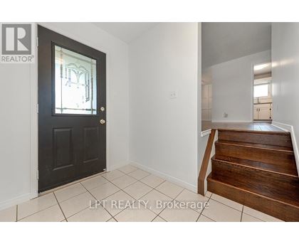 A black door with a glass window is in a room with white walls.