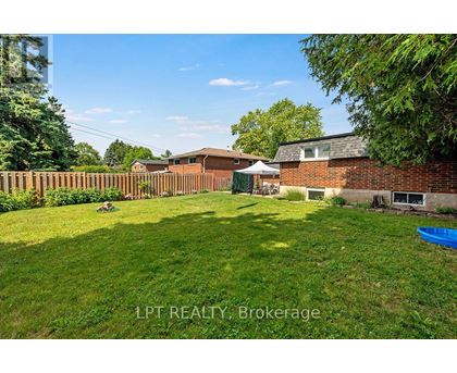 A backyard with a blue kiddie pool and a white umbrella.