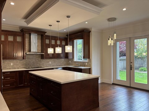 A kitchen with dark wood cabinets and a white countertop.