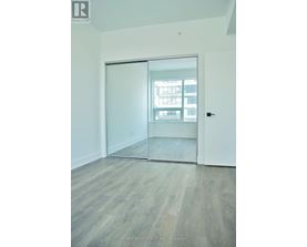 A room with a sliding glass door leading to a balcony.