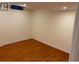 A room with wooden flooring and white walls.