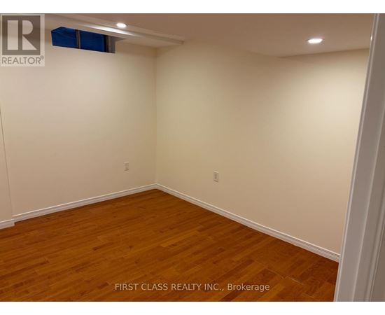 A room with wooden flooring and white walls.