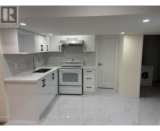 A white kitchen with a marble floor and a washing machine in the corner.