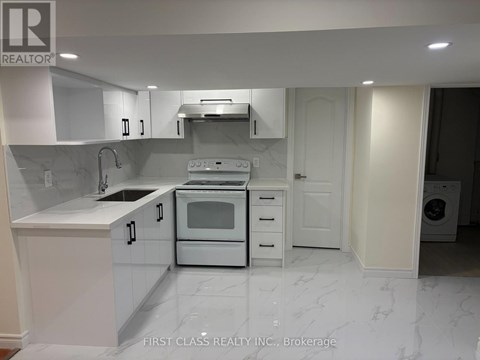 A white kitchen with a marble floor and a washing machine in the corner.