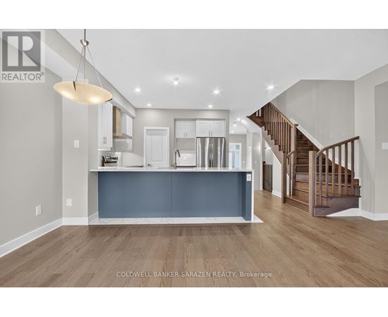 A spacious living room with a staircase leading to the upper floor.