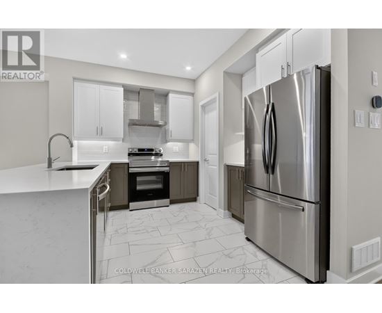 A modern kitchen with a stainless steel refrigerator and a marble floor.