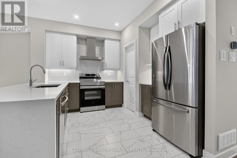 A modern kitchen with a stainless steel refrigerator and a marble floor.