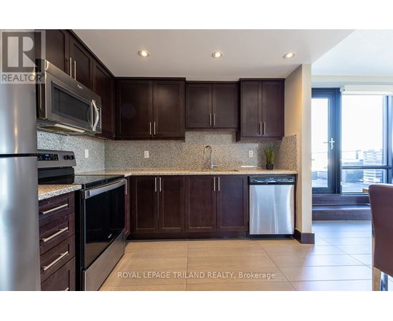 A kitchen with brown cabinets and a stainless steel refrigerator.