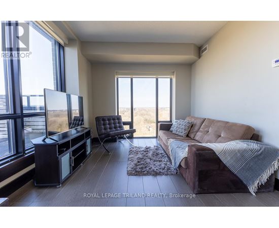 A living room with a brown couch and a flat screen TV.