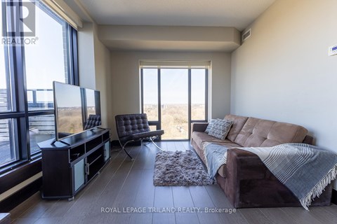 A living room with a brown couch and a flat screen TV.