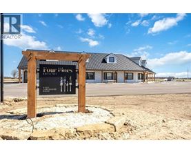 A sign for Four Pines Estates is displayed in front of a building.