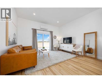 A living room with a brown leather sofa and a white cabinet.