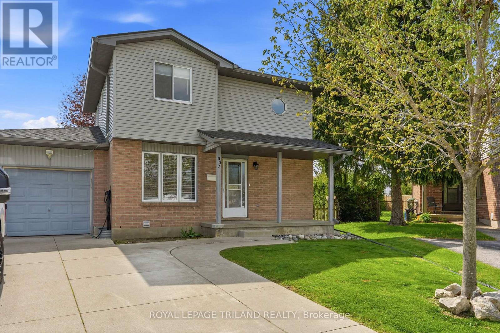 A house with a grey roof and a white garage door is for sale.