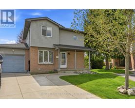 A house with a grey roof and a white garage door is for sale.