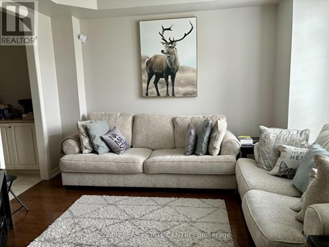 A living room with a couch and a painting of a deer on the wall.