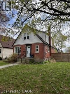 A house with a red door and a white wall.