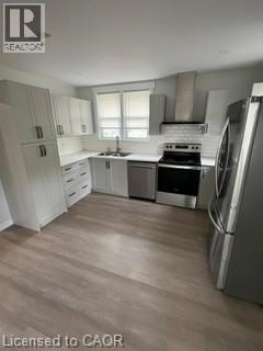 A kitchen with white cabinets and a stainless steel refrigerator.